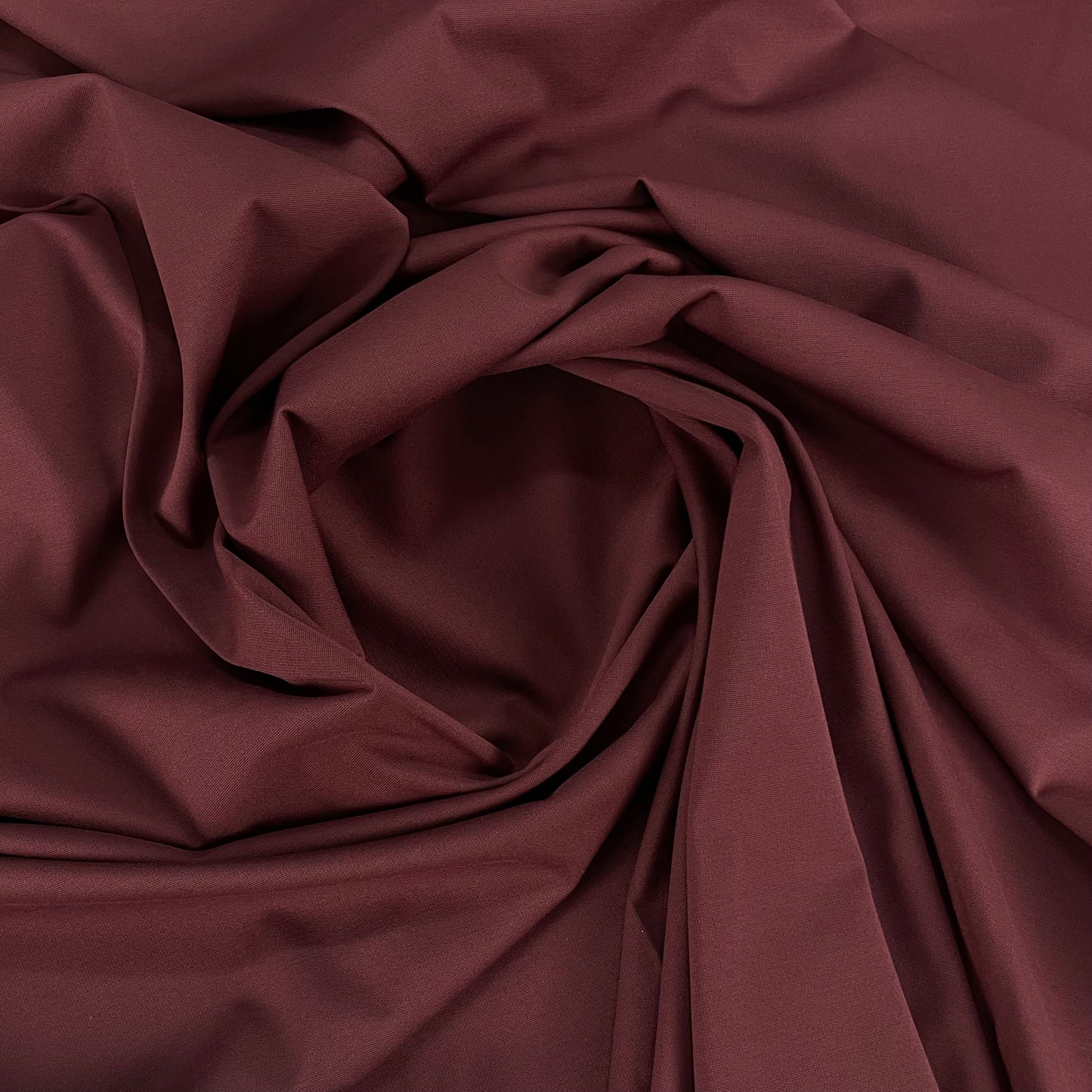 Tissu uni de couleur bordeaux, idéal pour la confection de vêtements