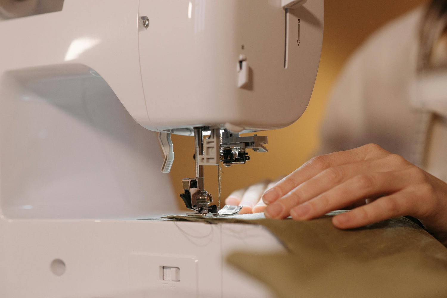 Mains guidant du tissu dans une machine à coudre pour un projet de couture